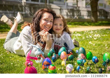 Portrait of a mother and daughter on a sunny spring day in the park on Happy Easter. 111986674