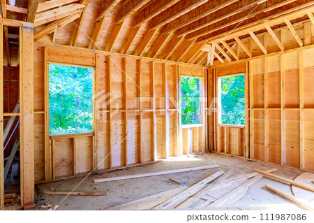 Unfinished space interior new house under construction with wooden framing beams Unfinished space interior new house under construction with wooden framing beams 111987086