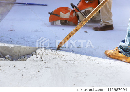 Wielding worker demolishes concrete old driveway at construction site 111987094