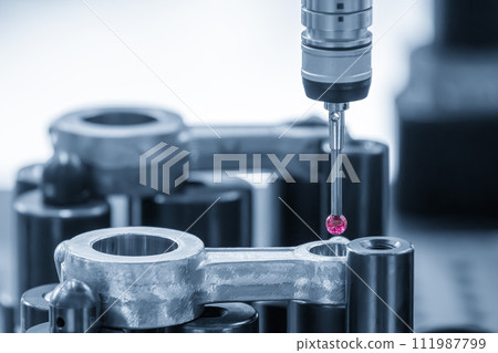 The  CMM probe measuring the  automotive parts in the light blue scene. 111987799