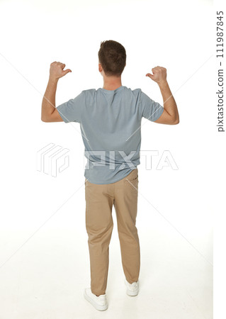 happy guy looking pointing to his back on white studio background 111987845