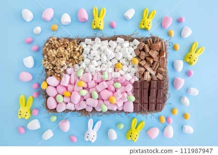 AI-generated content. Easter sweet charcuterie board with chocolate eggs, candies, cookies and marshmallows on white and blue background. Top view. Happy Easter. 111987947