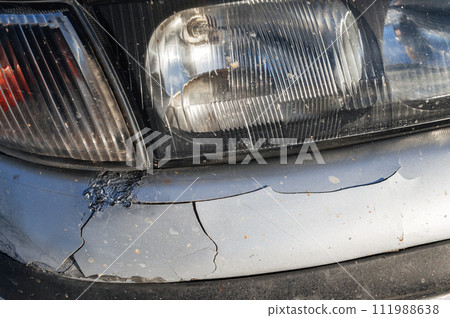 old car after an accident with damaged crumpled bumper close-up 111988638