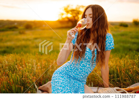 Young woman sits on a plaid with a book. Summer picnic in nature. Healthy food. Young woman sits on a plaid with a book. Summer picnic in nature. Healthy food. 111988787