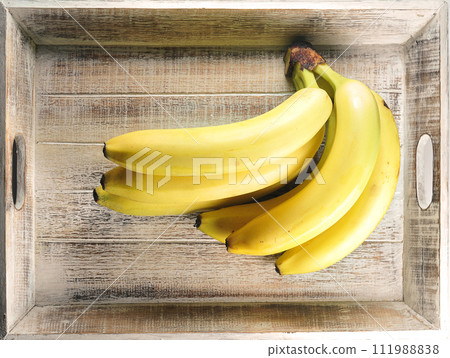 ripe yellow bananas in a wooden box 111988838