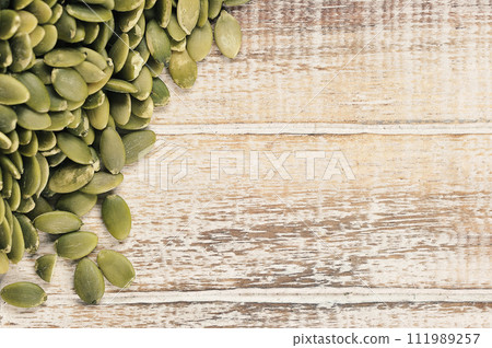 peeled pumpkin seeds on a wooden background 111989257
