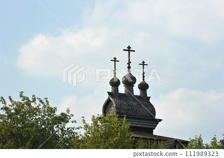 Russian architecture - wooden crosses on the roof of a wooden church in Kolomenskoye Park, Moscow 111989323