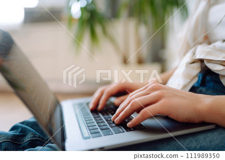 Close-up of woman's hands on a laptop keyboard, typing on modern laptop at home. Freelancing concept Close-up of woman's hands on a laptop keyboard, typing on modern laptop at home. Freelancing concept 111989350