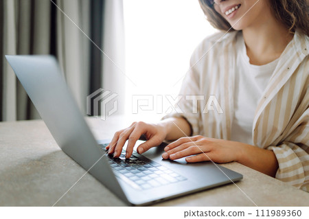 Close-up of woman's hands on a laptop keyboard, typing on modern laptop at home. Freelancing concept 111989360