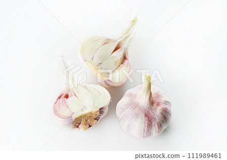 whole and cut in half garlic on a white background 111989461
