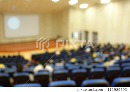 blurred or defocused people in the seminar convention hall. Business meeting for a press conference or lecturer education concept with a wide view from the room's corner. Modern, blurry auditorium. blurred or defocused people in the seminar convention hall. Business meeting for a press conference or lecturer education concept with a wide view from the room's corner. Modern, blurry auditorium. 111989593