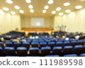 blurred or defocused people in the seminar convention hall. Business meeting for a press conference or lecturer education concept with a wide view from the room's corner. Modern, blurry auditorium. 111989598