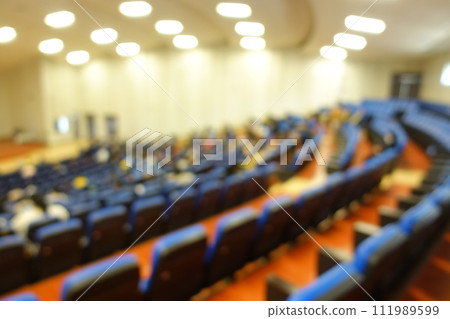 blurred or defocused people in the seminar convention hall. Business meeting for a press conference or lecturer education concept with a wide view from the room's corner. Modern, blurry auditorium. blurred or defocused people in the seminar convention hall. Business meeting for a press conference or lecturer education concept with a wide view from the room's corner. Modern, blurry auditorium. 111989599