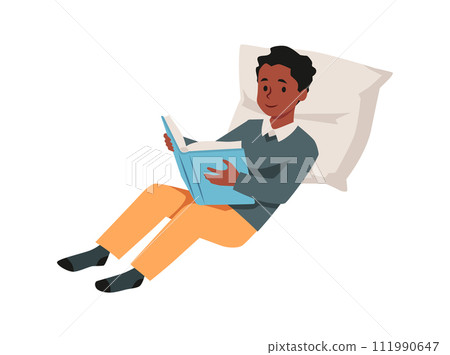 A teenage boy lies on a pillow, deeply immersed in a book. 111990647