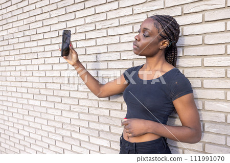 Young Woman Capturing Selfie by White Brick Wall Young Woman Capturing Selfie by White Brick Wall 111991070