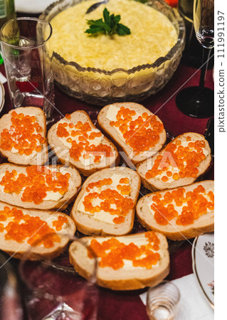Homemade festive lunch with sandwiches, red caviar, and butter on table Homemade festive lunch with sandwiches, red caviar, and butter on table 111991197