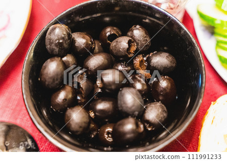 Black olives in bowl on festive table, perfect appetizer for holiday gatherings 111991233