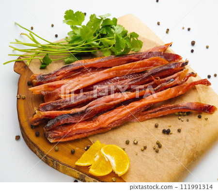Sliced smoked salmon belly with fresh parsley. Isolated over white background Sliced smoked salmon belly with fresh parsley. Isolated over white background 111991314
