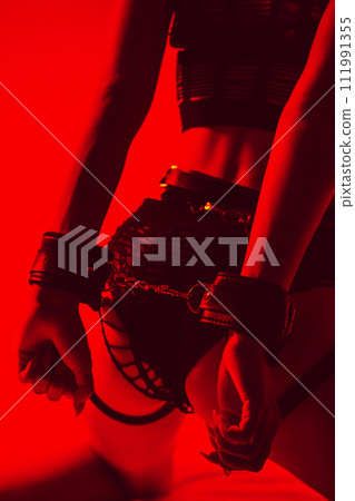 sexy ass of submissive slave girl woman with hands in BDSM handcuffs 111991355