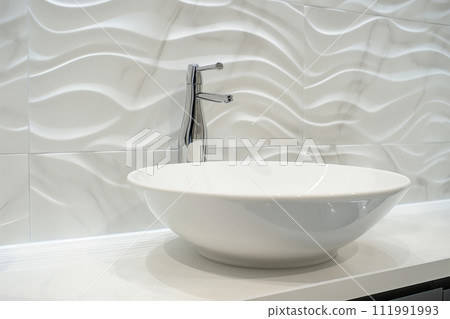Modern bathroom with white vessel sink and sleek faucet 111991993