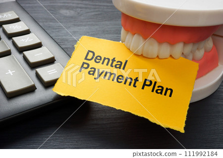 Dental payment plan. Calculator and jaws holding a sheet. Dental payment plan. Calculator and jaws holding a sheet. 111992184