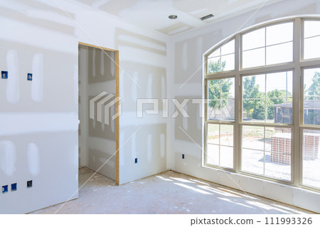 Gypsum plaster walls are in process of being finished for painting in new home 111993326