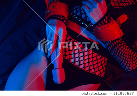 female hands in leather BDSM handcuffs hold a vibrator for masturbation and orgasm. Submissive woman girl with a sex toy female hands in leather BDSM handcuffs hold a vibrator for masturbation and orgasm. Submissive woman girl with a sex toy 111993657