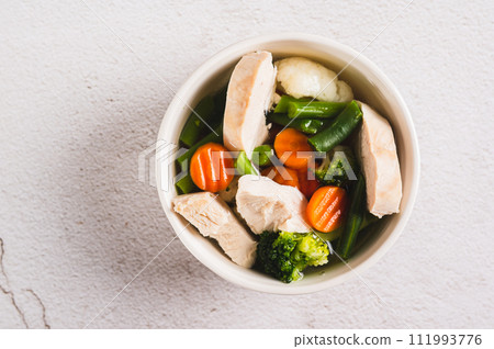 Close up of  soup with chicken, cauliflower, broccoli, carrots and green beans in a bowl top view 111993776