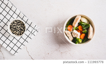 Diet soup with chicken fillet and boiled vegetables in a bowl on the table top view web banner Diet soup with chicken fillet and boiled vegetables in a bowl on the table top view web banner 111993778