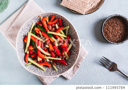 Vegetarian salad of red beans, cucumber and bell pepper in a bowl on the table top view 111993784
