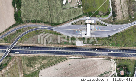 Bird's-eye view of a car passing a toll road 111994418