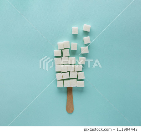 refined sugar cubes on an ice cream stick, sugar in ice cream 111994442