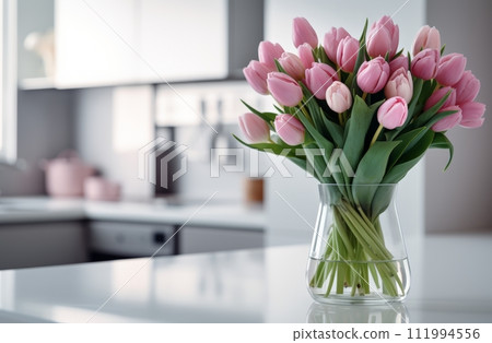 pretty pink tulips in a vase in middle of a kitchen pretty pink tulips in a vase in middle of a kitchen 111994556