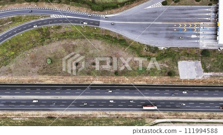 An overhead perspective of a highway featuring two lanes for vehicles to travel. The road stretches into the distance, with cars and trucks moving in different directions. An overhead perspective of a highway featuring two lanes for vehicles to travel. The road stretches into the distance, with cars and trucks moving in different directions. 111994588