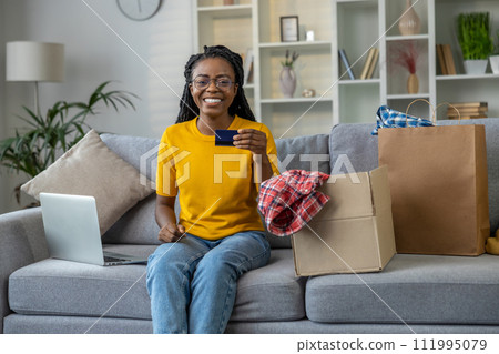 Young smiling woman looking happy while paying online 111995079