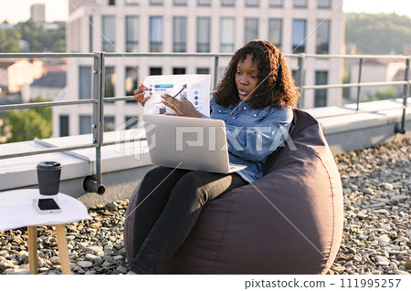 African female giving online presentation using headset and computer. 111995257