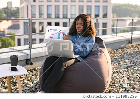 African female giving online presentation using headset and computer. African female giving online presentation using headset and computer. 111995259