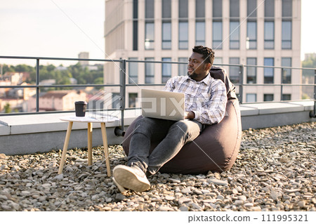 Business man in casual checkered shirt working on laptop. Business man in casual checkered shirt working on laptop. 111995321