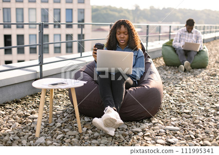 African American woman taking pleasure of online shopping during coffee break. African American woman taking pleasure of online shopping during coffee break. 111995341