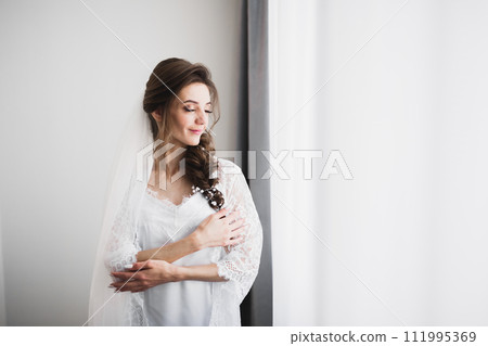 Luxury bride in white dress posing while preparing for the wedding ceremony Luxury bride in white dress posing while preparing for the wedding ceremony 111995369