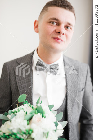Beautiful man, groom holding big and beautiful wedding bouquet with flowers 111995372