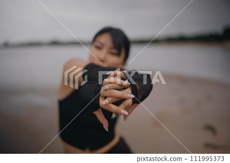 contemporary dancer in black clothes dancing in the sea 111995373