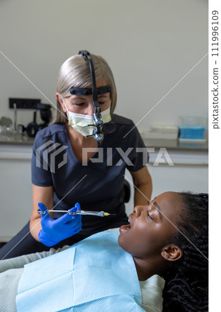 Dentist checking teeth of patient woman sitting in medical center 111996109