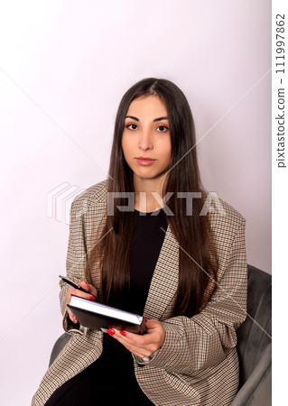 Beautiful woman in business style with diary on white background. Business Beautiful woman in business style with diary on white background. Business 111997862