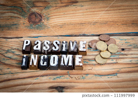 Passive income. Alphabet letters on wood texture background 111997999