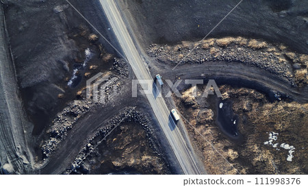 Arctic landscape in iceland, beautiful icelandic fields and roads in countryside. Natural frozen black lands with snow forming scandinavian scenery. Drone shot. Aerial view. Arctic landscape in iceland, beautiful icelandic fields and roads in countryside. Natural frozen black lands with snow forming scandinavian scenery. Drone shot. Aerial view. 111998376