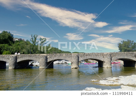 Leisurely Canoeing Under the Stone Bridge in Ardeche 111998411