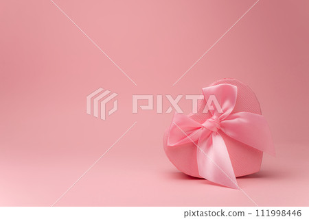 Heart Gift box with ribbon on pink surface Heart Gift box with ribbon on pink surface 111998446