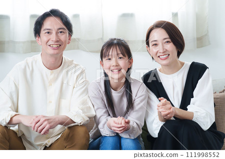 Parents and children watching TV in the living room 111998552