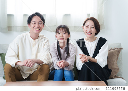 Parents and children watching TV in the living room 111998556